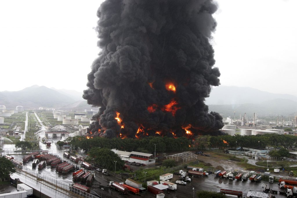 Firefighters try to extinguish a fire at an oil refinery in Puerto La Cruz
